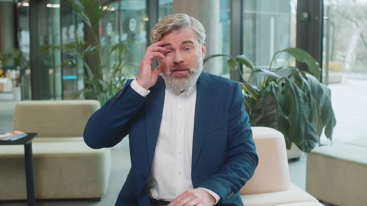 un hombre de negocios enojado levantando las manos en expresión de indignación preguntando la razón del fracaso en el vestíbulo de la oficina