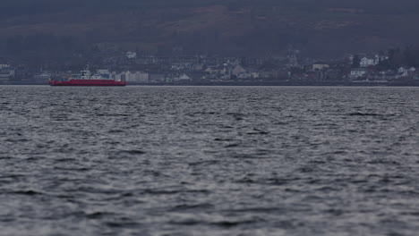 Fernsicht-Auf-Ein-Riesiges-Industrieschiff,-Das-An-Einer-Küstenstadt-Vorbeifährt