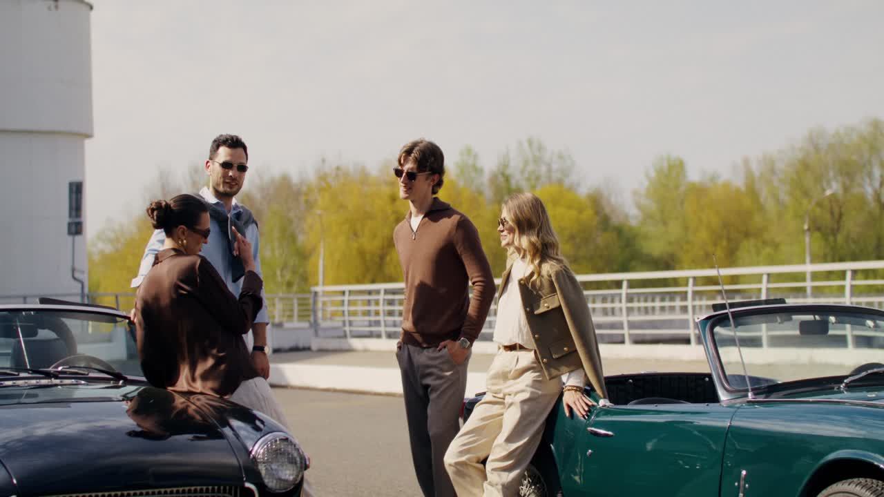 Friends enjoying a sunny day by vintage cars