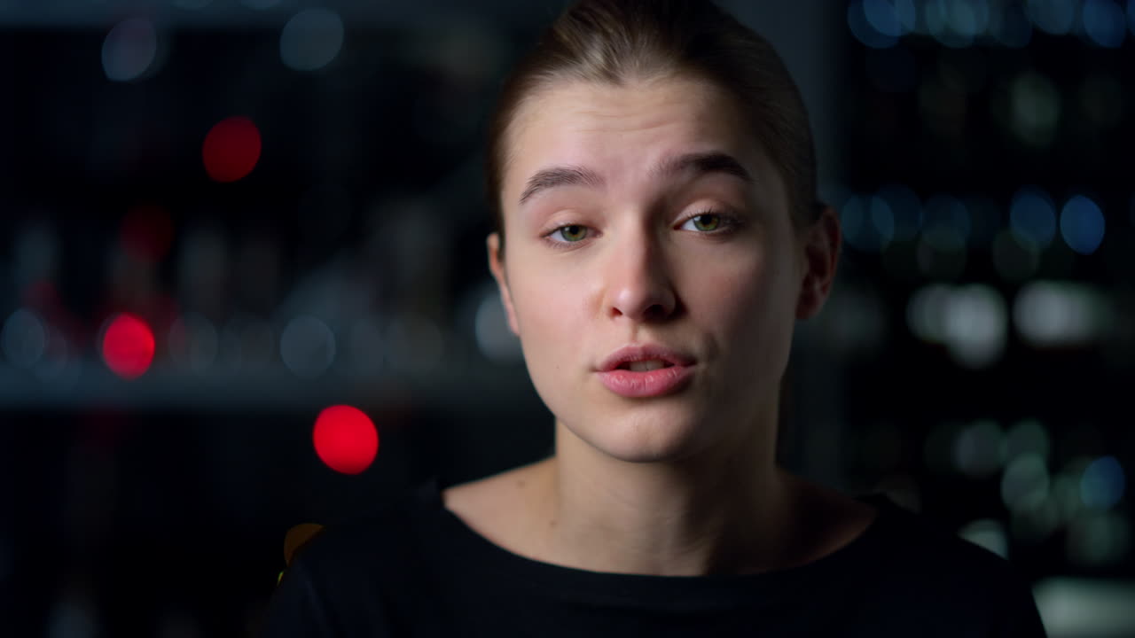 멋진 소녀의 초상화 실내에서 어깨를 끄덕이는 소녀의 입술을  ⁇ 는 소녀.