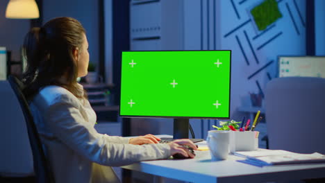 Businesswoman-looking-at-green-screen-monitor-of-computer