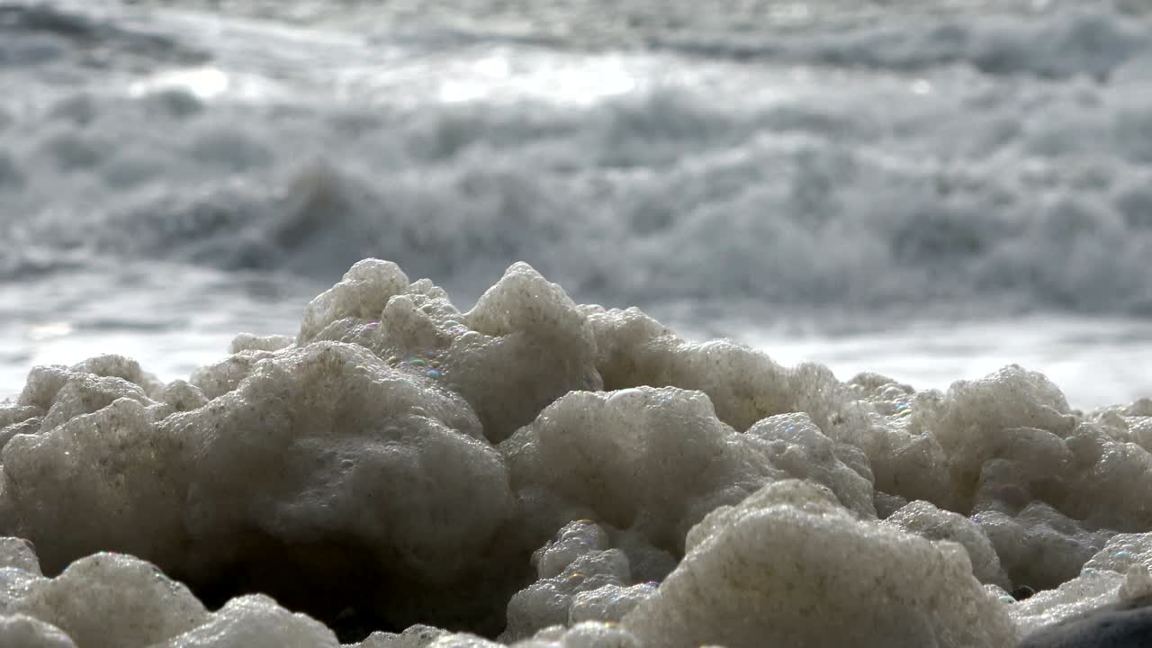 Algae foam in storm on the beach, sandy beach with waves, North Sea, Jütland, Sondervig, Denmark, 4K