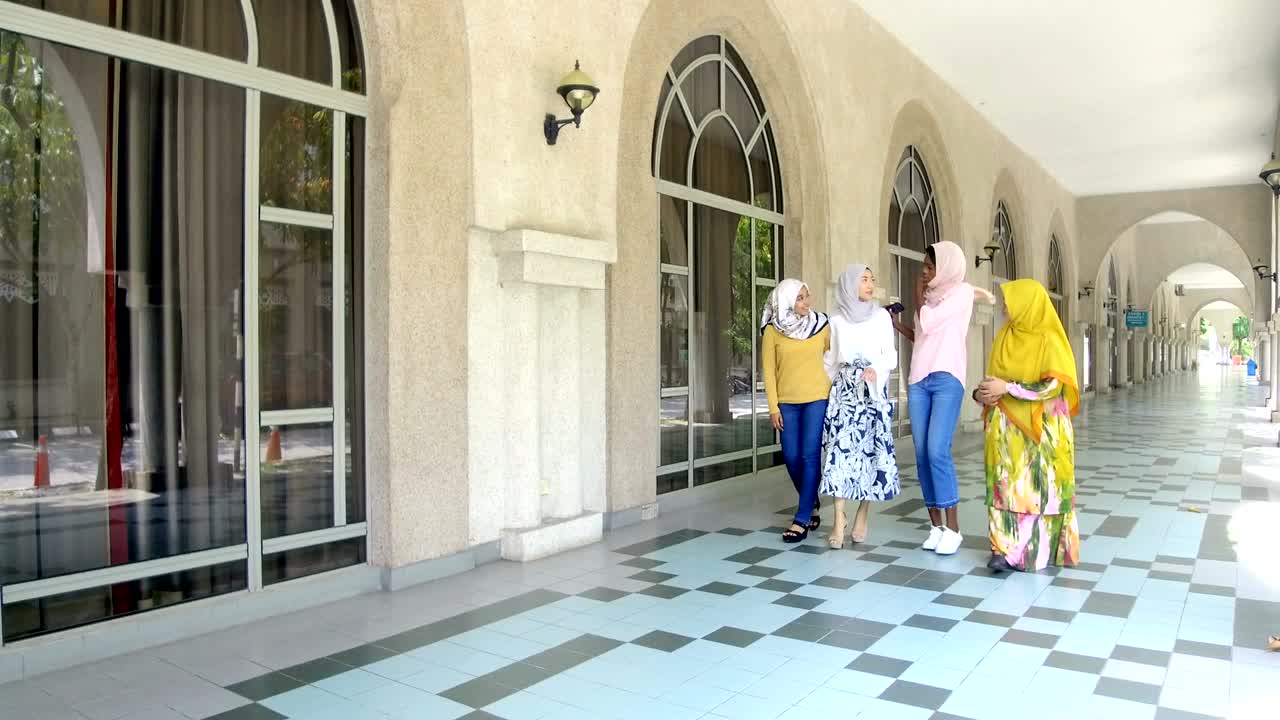 히자브를 입은 대학생들이 그룹으로 고 있습니다.