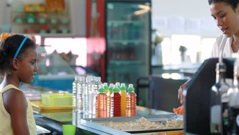 mujer sirviendo comida a los niños