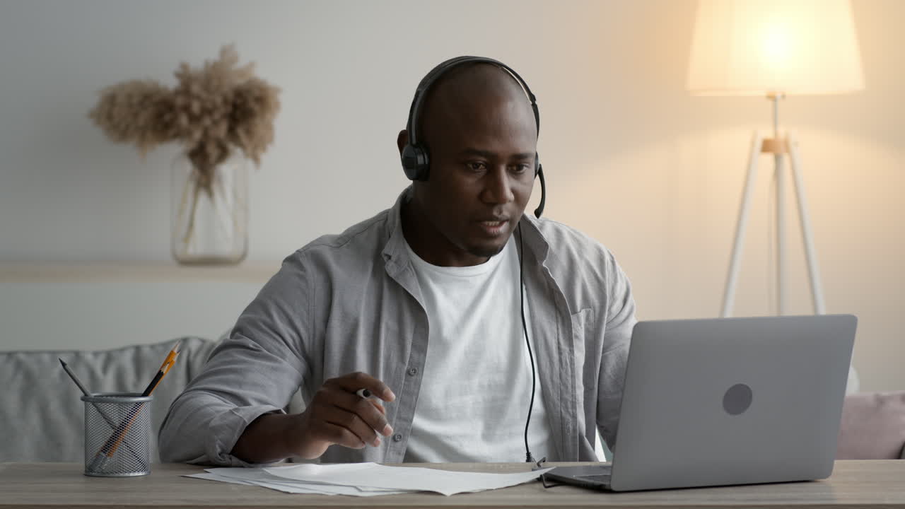 African American Man in Headphones Working or Studying from Home with Laptop