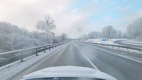 highspeed drive over a german motorway under snowy, wet conditions at a morning after snowfall and with a blue cloudy sky