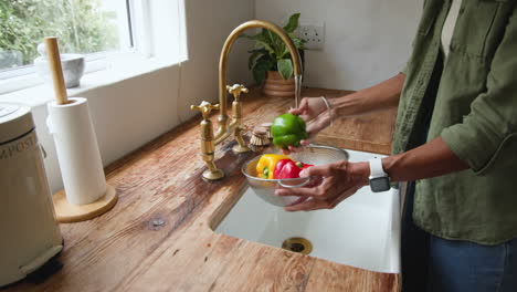 washing fresh vegetables in kitchen sink, preparing healthy meal at home