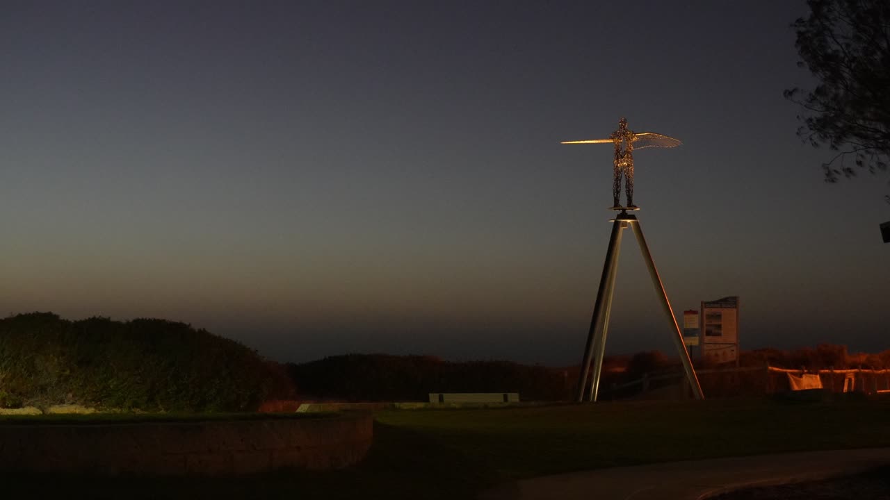 Foto malam yang menakjubkan dari The Sentinel, sebuah karya seni baja tahan karat yang dipoles oleh Simon Gilby di Quinns Rocks, Perth, diterangi dengan indah dengan latar belakang langit malam yang cerah.