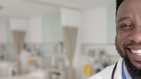 unaltered portrait of happy african american male doctor with stethoscope looking at camera