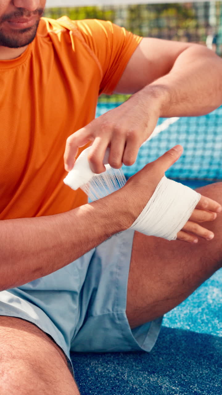 Homem Enfaixando a Mão com Bandagem em uma Quadra Esportiva
