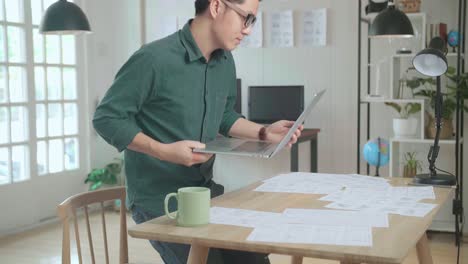 asian man works with laptop computer and storyboard. stand up and walking out frame, comics compilation, application ui or game plot