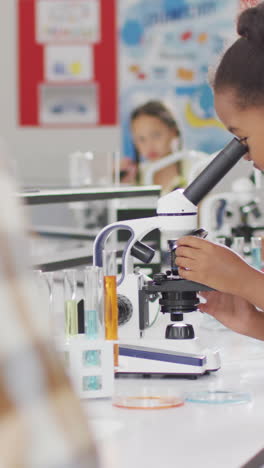 video of happy african american girl with microscope during lesson