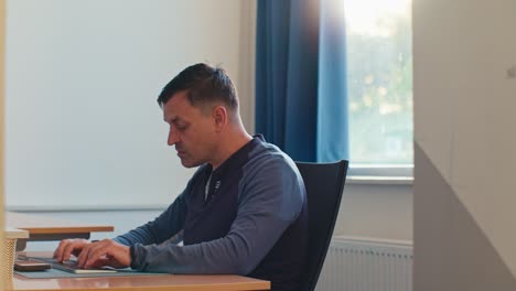 busy European Dutch Caucasian white man male adult model working in the office job on desktop workspace next to the window and feels tired fatigue