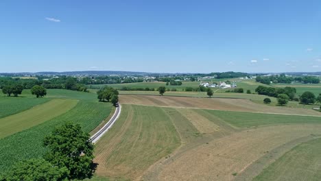 an aerial view of thomas the tank engine approaching in the distance by it's self rounding a curve in the track on a beautiful day