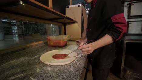 chef preparing pizza toppings in a restaurant kitchen