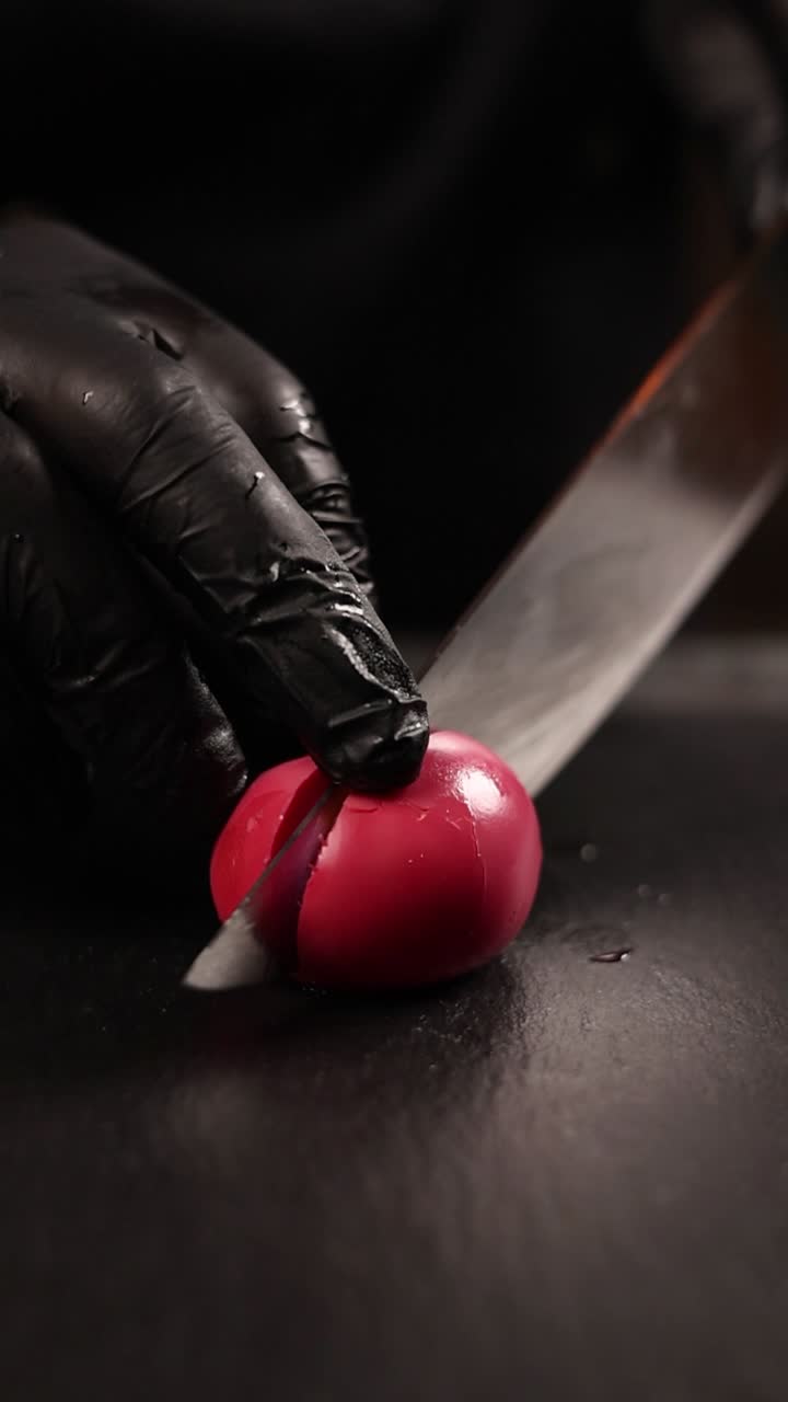 el chef corta un huevo rosa.