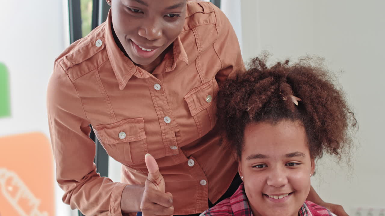 Smiling african american teenage girl listening to female doctor pediatrician school psychologist