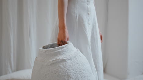 artist hand holding vase in creative studio closeup. woman decorator at home