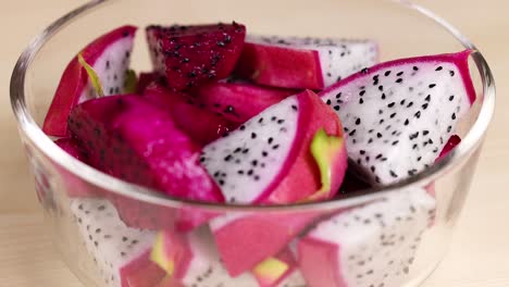 sliced dragon fruit displayed in a clear bowl