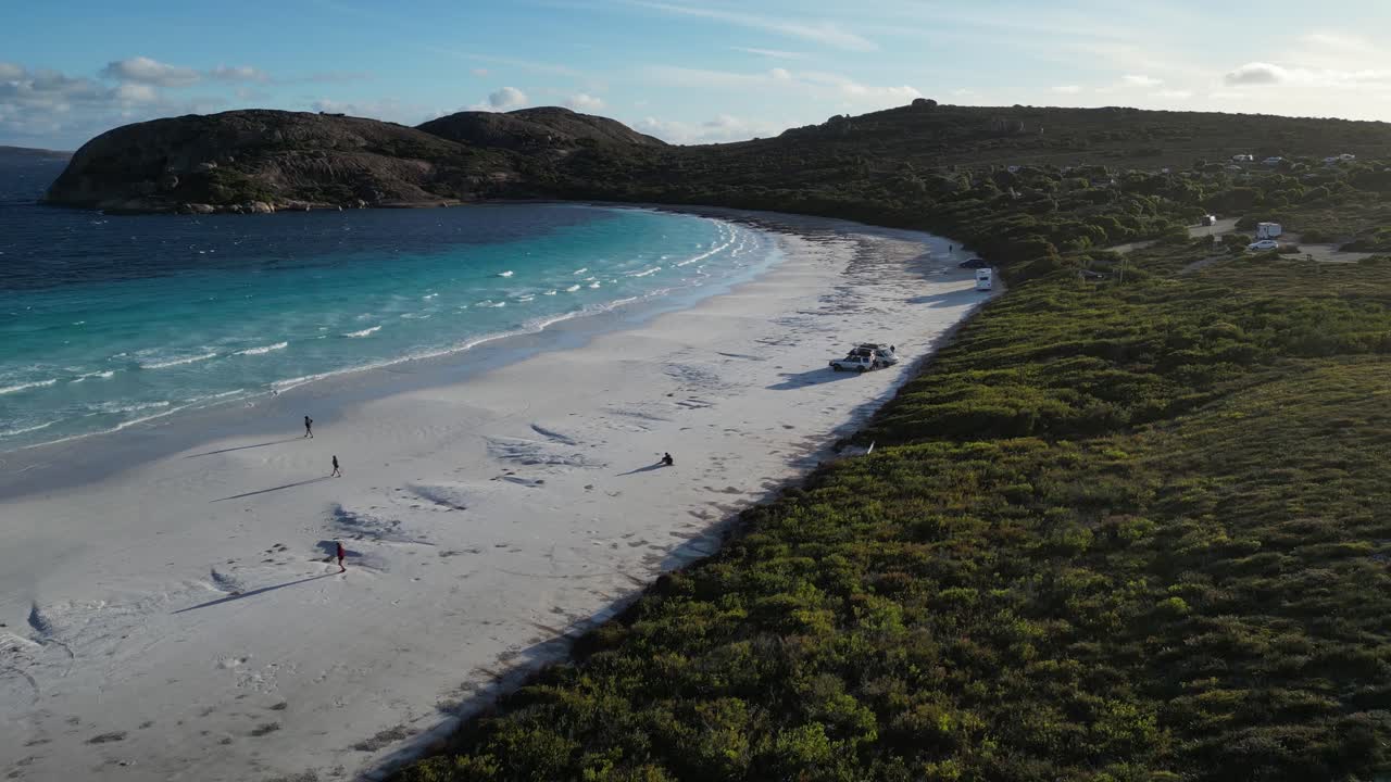 la gente camina a lo largo de las aguas azules en la playa de lucky bay en australia occidental