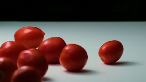 slow-motion footage of red tomatoes rolling on a table