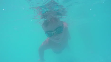 kid diving in blue water of swimming pool