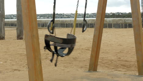 empty rubber toddler swing at a coastal playground