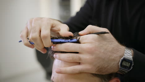 close-up of a barber cutting a man's hair
