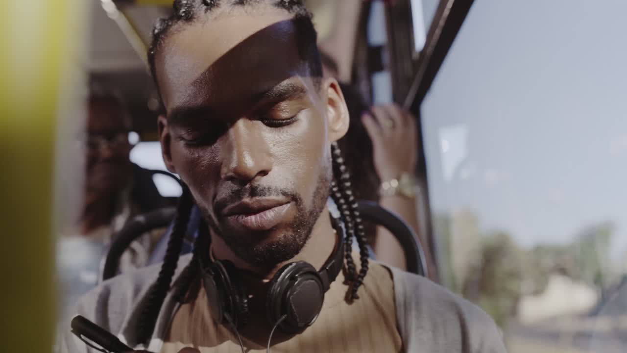 Man writing with headphones on a bus