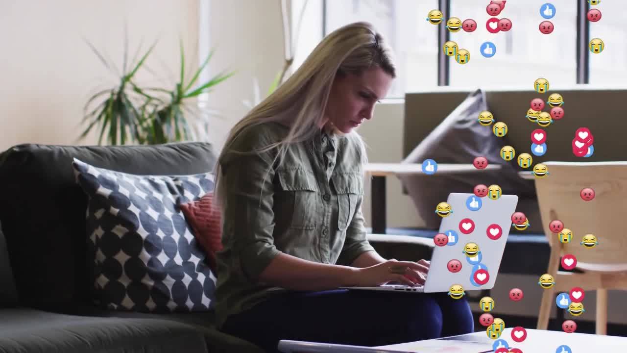 animación de iconos emoji sobre una mujer de negocios caucásica que usa una computadora portátil
