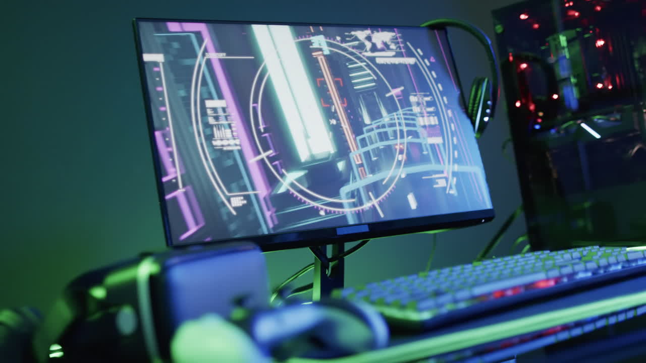 Video of computer and gaming equipment on desk with copy space on neon background