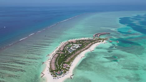 Pristine island resort with overwater bungalows in Maldives. Aerial backward, copy space