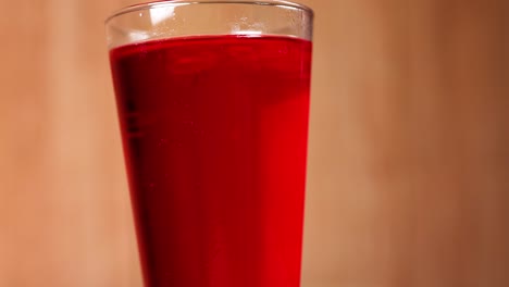 a glass filled with red soft drink