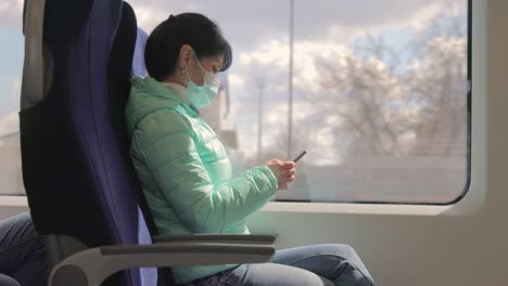 Una-Mujer-Que-Lleva-Una-Mascarilla-Médica-Protectora-Viaja-En-Un-Tren-Durante-La-Cuarentena-De-Covid-19.