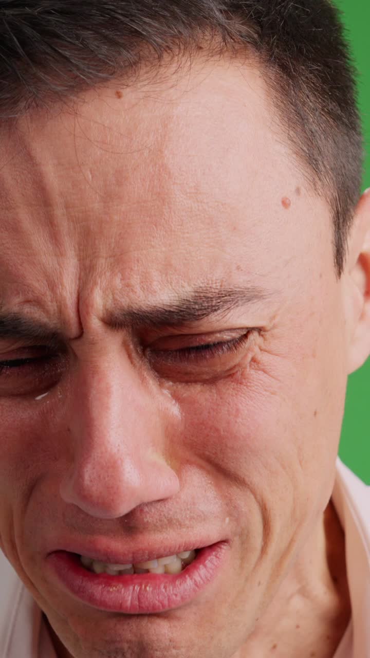 Sad man crying desperately on green screen background