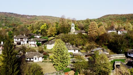 Pintoresco-Pueblo-Tradicional-Búlgaro-Remoto-En-El-Bosque-Otoño-Disparo-De-Drone