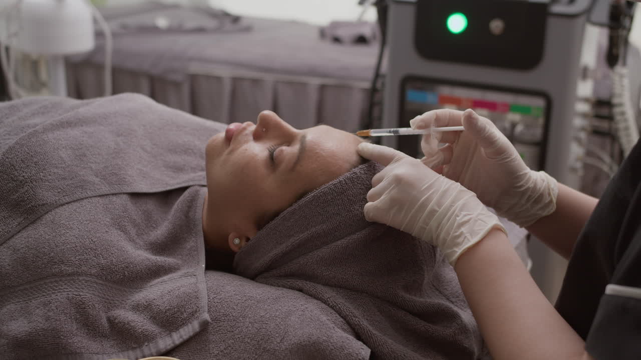 Young Woman Getting Beauty Injections in Forehead at Clinic