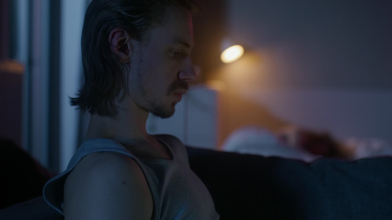 Un giovane uomo seduto da solo di notte