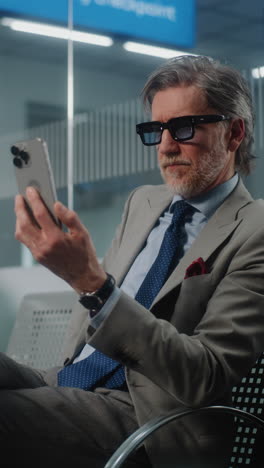 businessman using smartphone in airport lounge