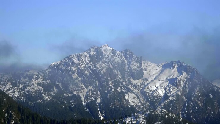 Mist Drifting Across Rugged Landscape And Snow-covered Peaks Of Coastal Mountains In British Columbia, Canada. aerial hyperlapse