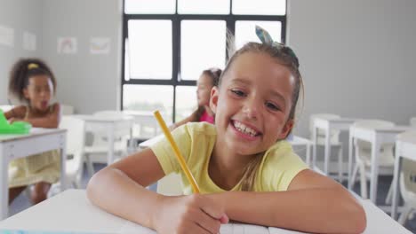 Video-De-Una-Feliz-Niña-Caucásica-Sentada-En-El-Pupitre-De-La-Escuela-Y-Aprendiendo