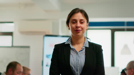 mujer empresaria sonriendo a la cámara de pie en la sala de conferencias