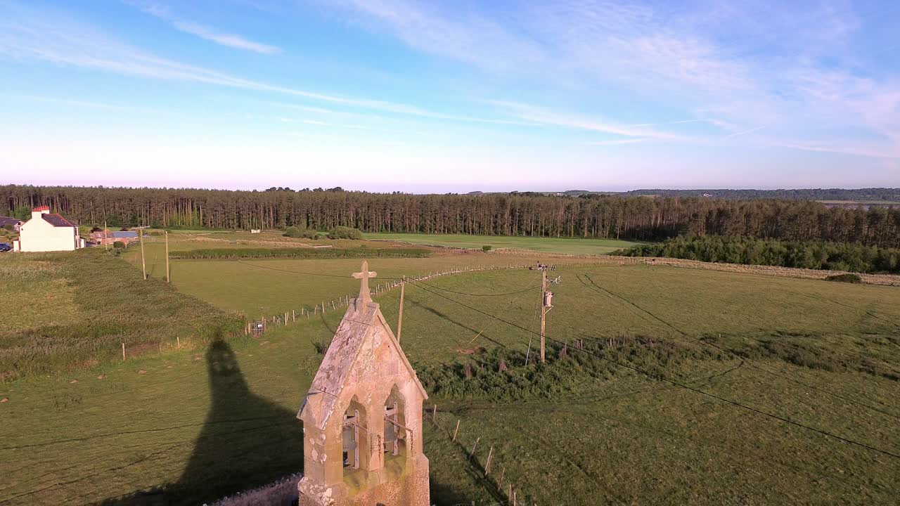 St Peters church in rural Newborough aerial view establishing bell tower in early morning sunrise