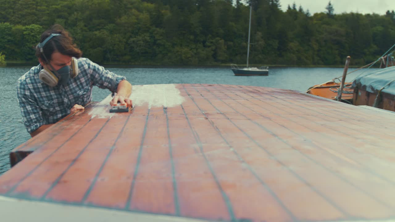 Sanding wood boat wheelhouse cabin by hand, WIDE SHOT