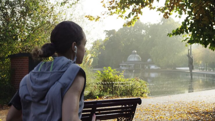 Runner woman running in park exercising outdoors fitness tracker wearable technology
