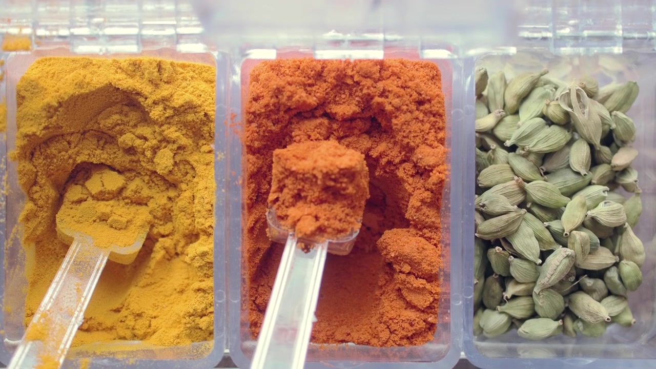 Scooping Red Chili Powder from a Spice Container
