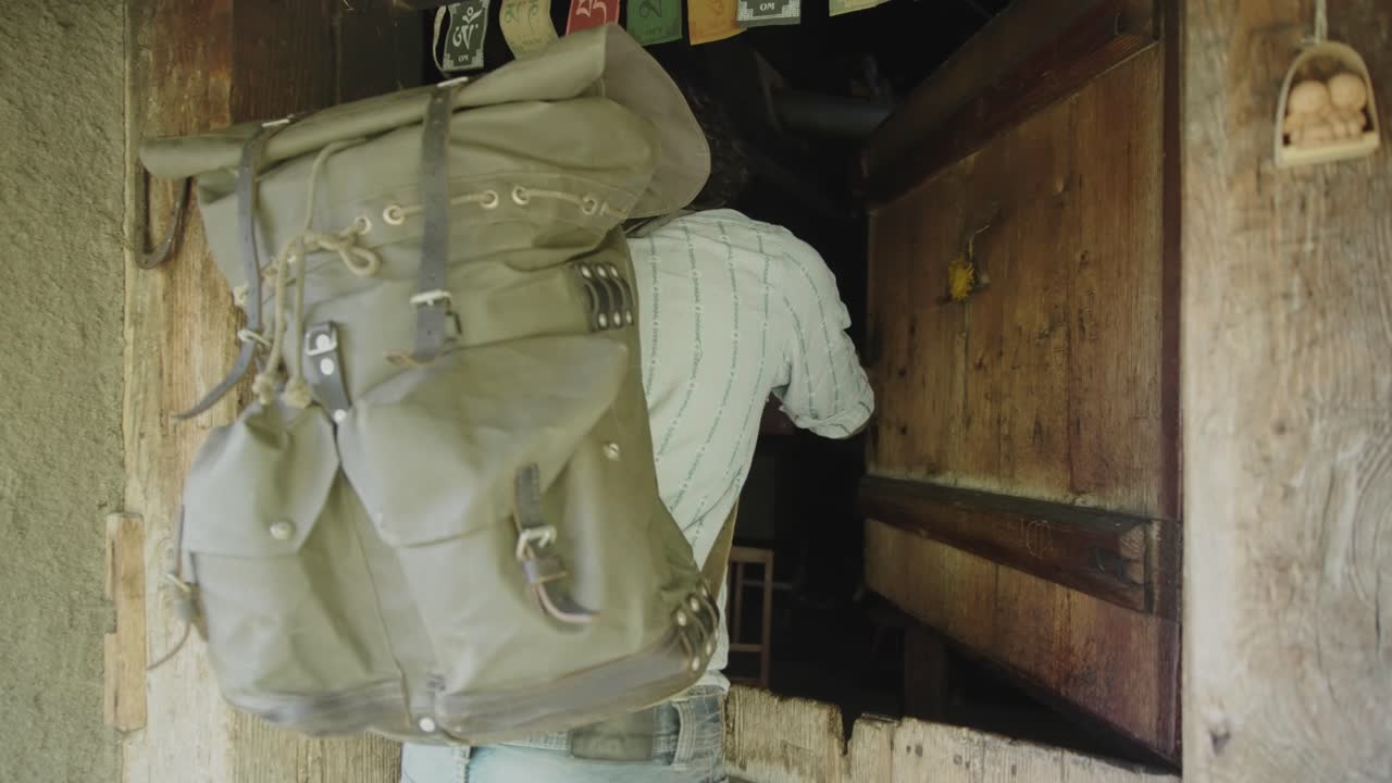 소박한 나무 선실 문을 여는 백인 남자 백패커 탐험가