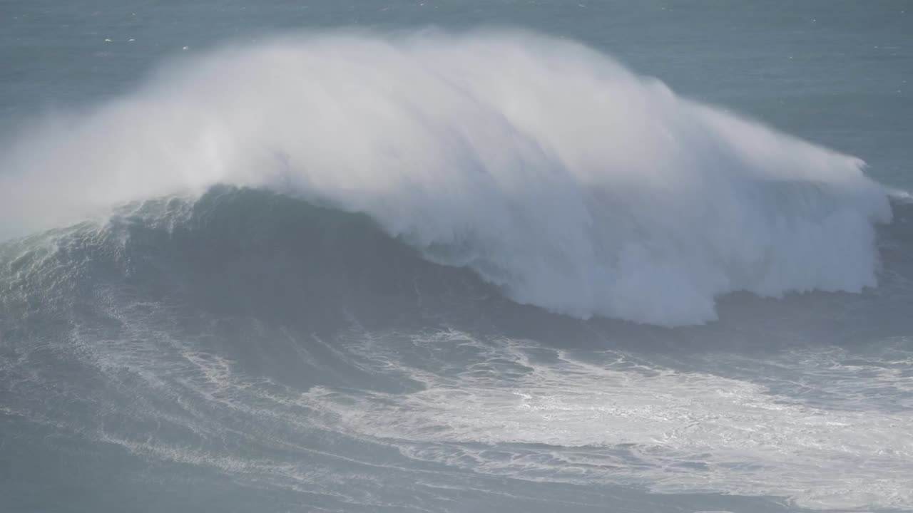 Majestic waves crashing at Nazare, Portugal, with surfers navigating the ocean's power