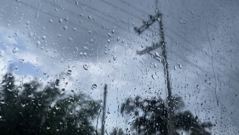 looking at power lines as rain runs down the glass of a window on miserable day