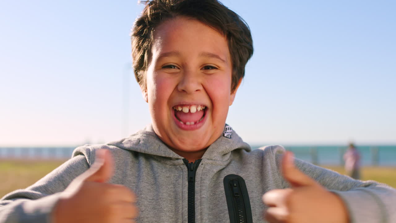 소년, 엄지 손가락을 들고 행복한 소년의 얼굴을 흥분